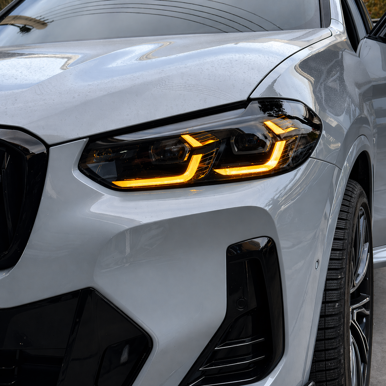 Close-up of a white X3/X4 headlight with amber DRL