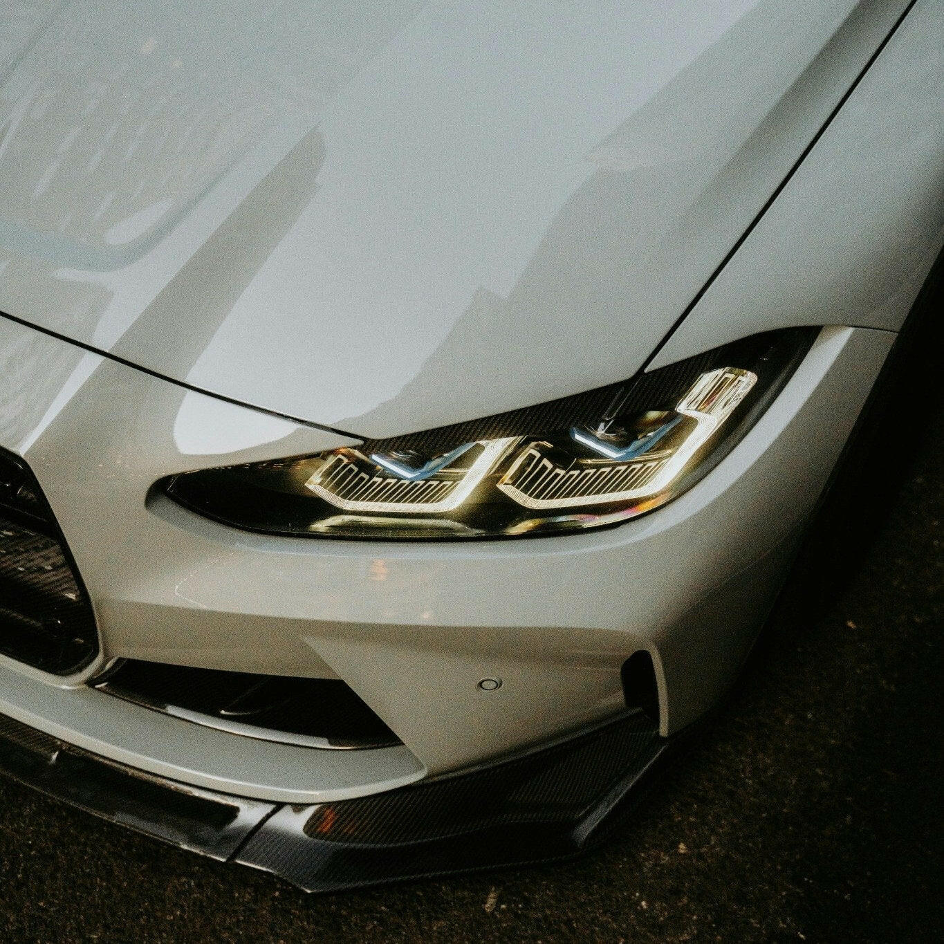 Close-up of a car's headlight on a white vehicle